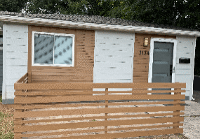 Small house with wooden slat fence